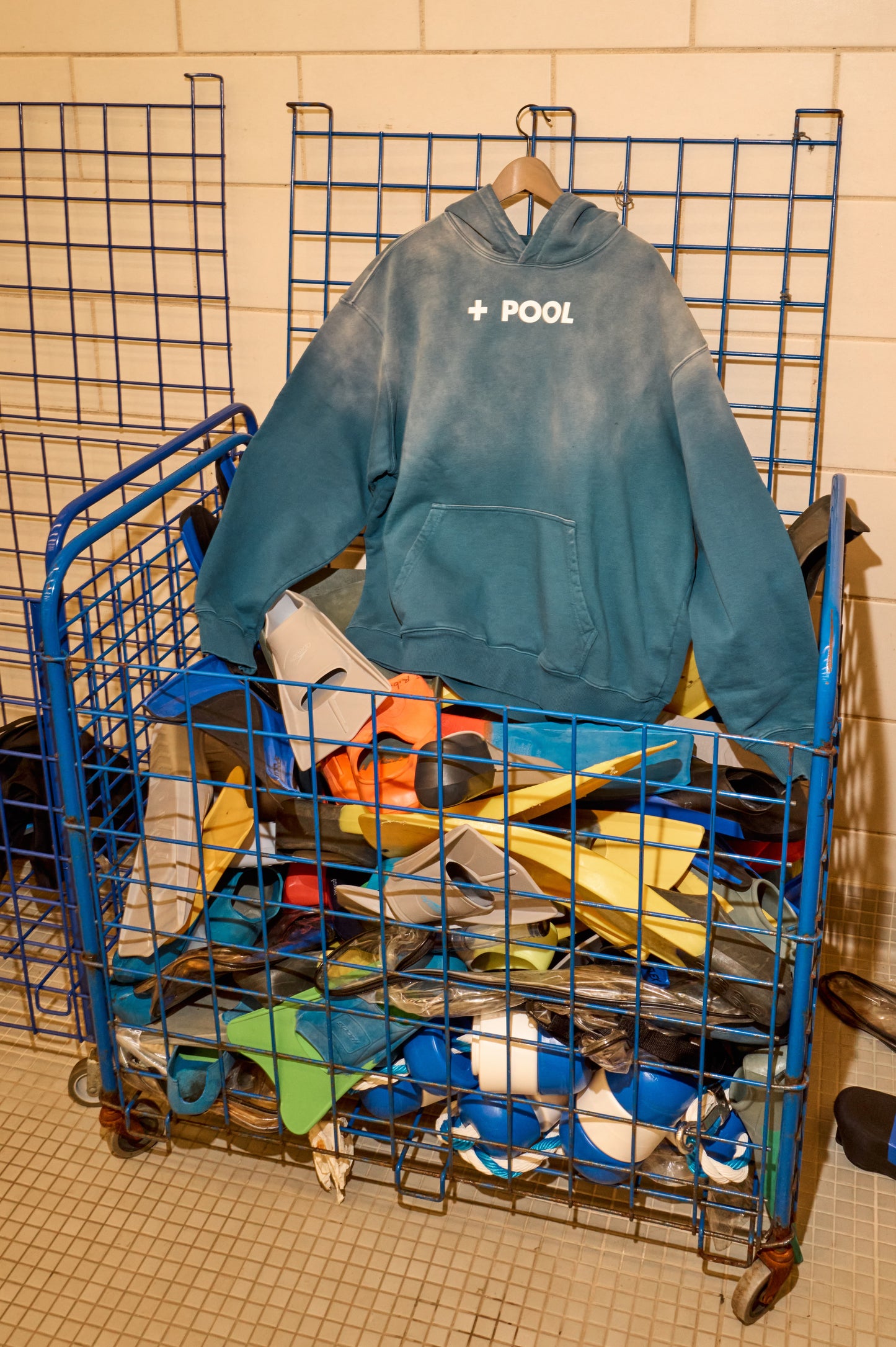 A blue hoodie on top of a basket of pool gear.